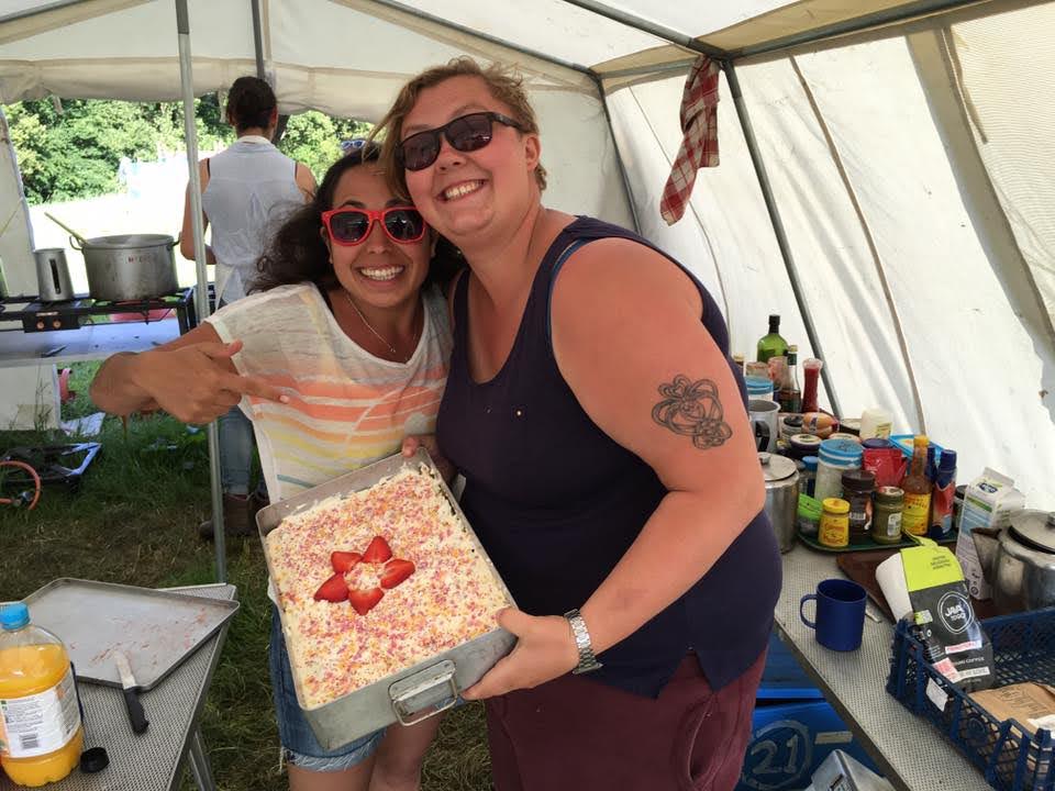 two people in sunglasses holding a large pudding in a tent