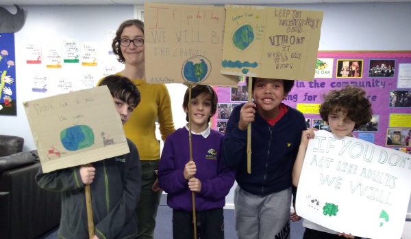 4 children holding banners reading "if you can't act we will" and "there is no planet B"