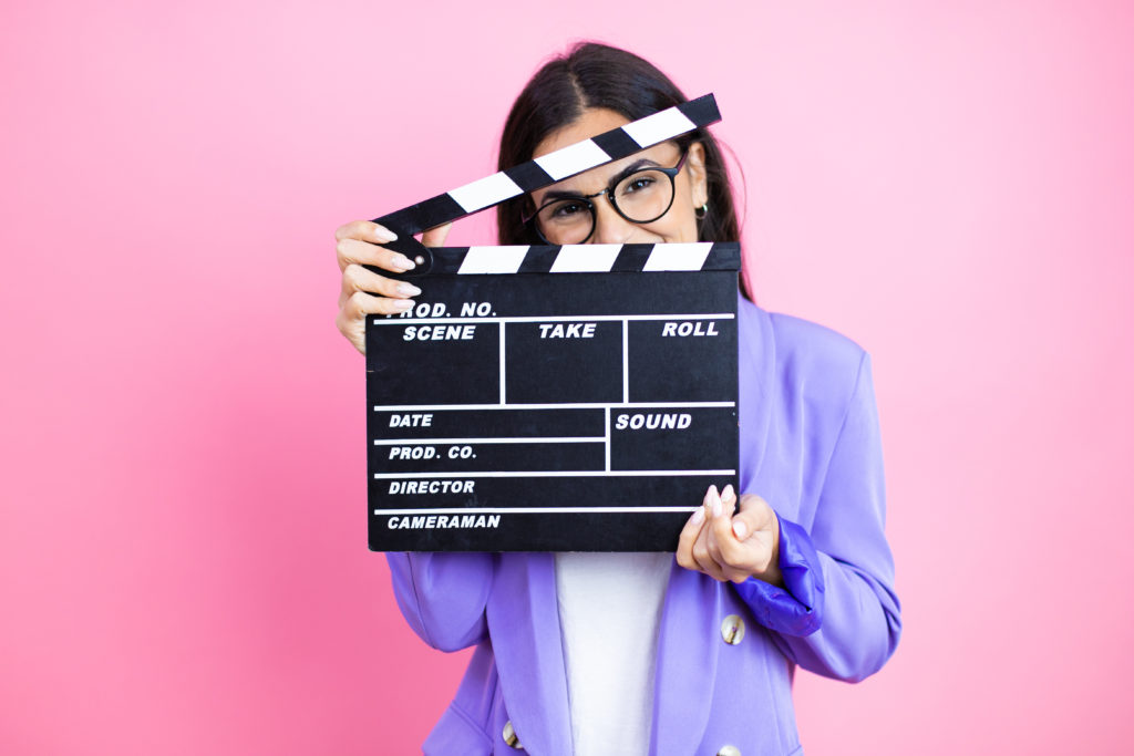 Young business woman wearing purple jacket over pink background