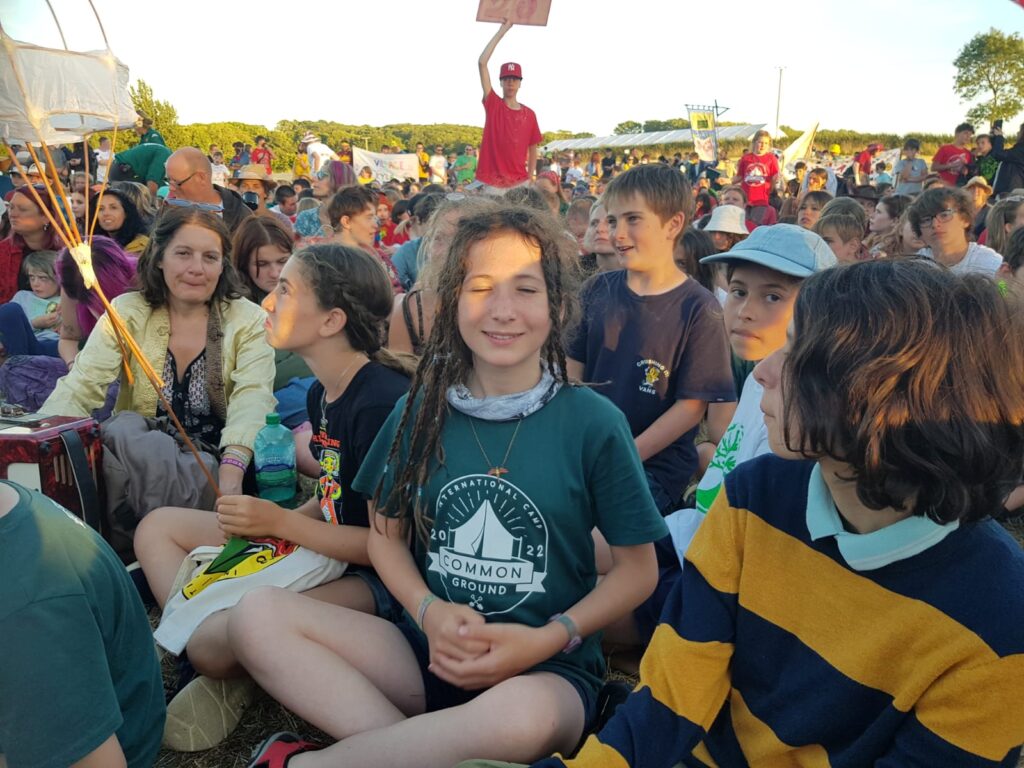 A crowd of young people sitting down in a field