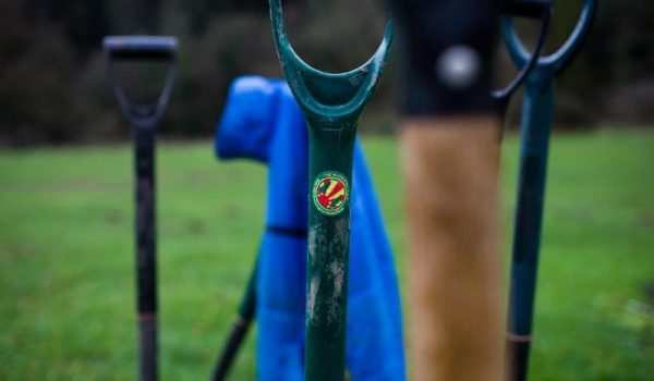 spades stuck in the ground with woodcraft folk sticker o the handle