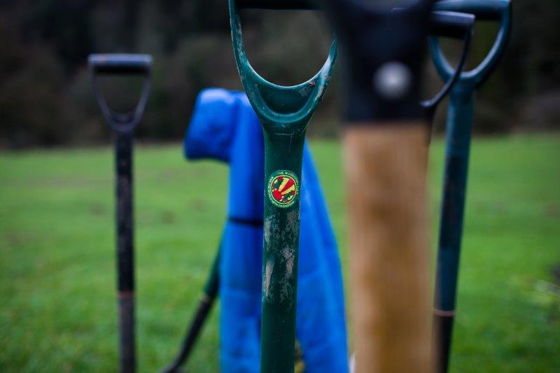 spades stuck in the ground with woodcraft folk sticker o the handle