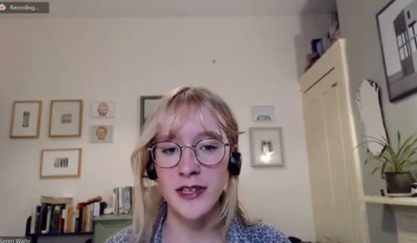 Young woman sitting at zoom screen in headphones