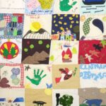 A large textile quilt made by Woodcraft Folk Elfin Groups. You can see the names of some groups on the quilt, Brightlingsea Elfins, and Clapham District.